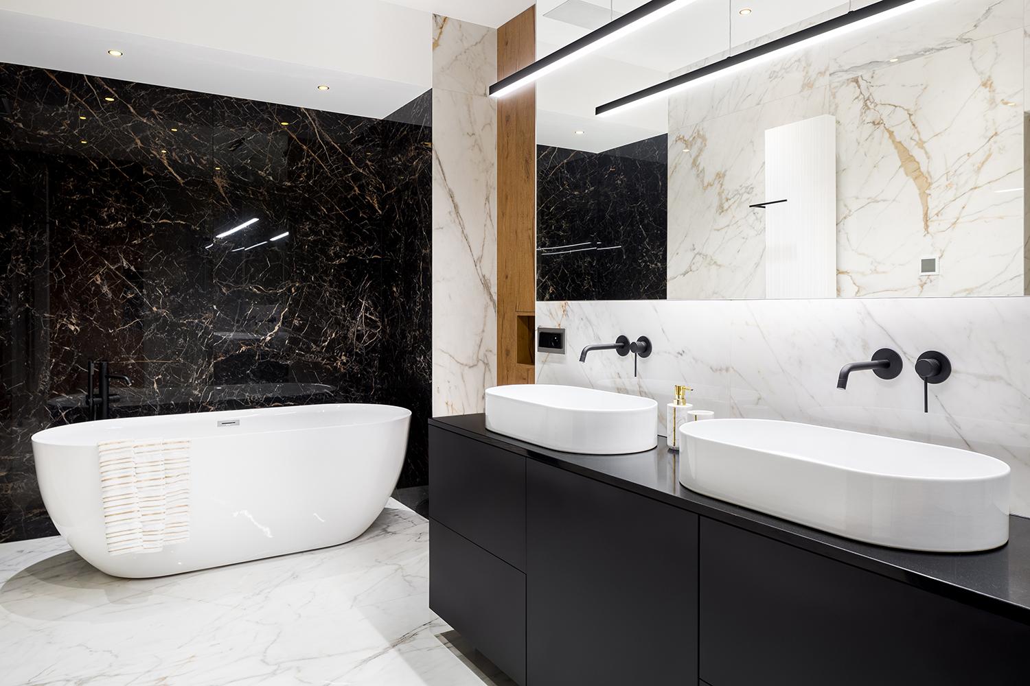 Luxury bathroom with dark and bright marble tiles and big bathtub